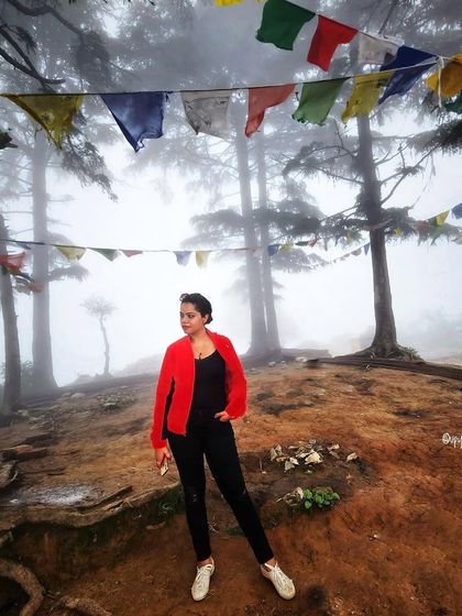 Exploring the misty hills of Mussoorie. A pop of red in the jacket stands out against the foggy, atmospheric background.