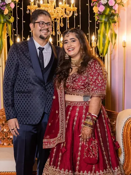 A video and photo series of this bride's reception look. She is glowing with happiness. Her makeup is glamorous with a bold red lip, and her hair is styled in soft waves, creating a stunning look for her celebration.