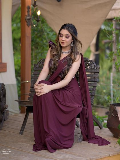 A full view of this stunning cocktail glam. The deep maroon sari is complemented by a sultry smoky eye and soft waves, creating a look of pure elegance.