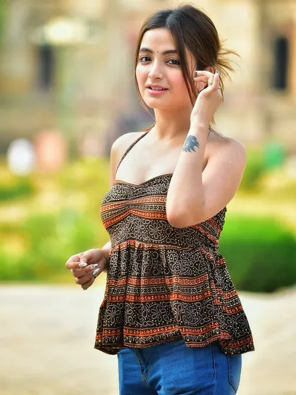 A beautiful portrait that highlights her features and the tattoo on her arm. The soft, natural light is very flattering and creates a warm mood.