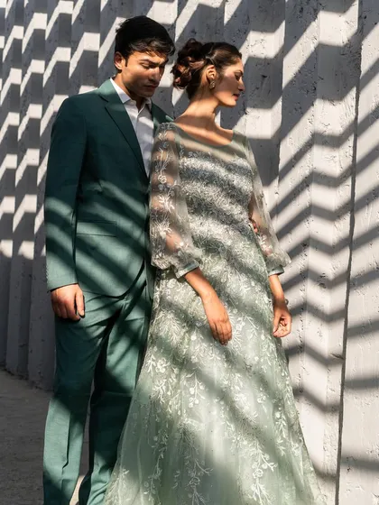 A perfect match in pastel green. This look features an elegant embroidered gown for her and a tailored green suit for him, creating a fresh and sophisticated vibe for a pre-wedding shoot or daytime event.