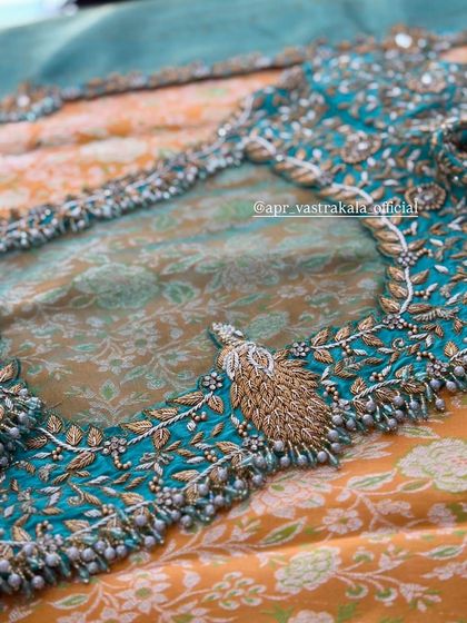 The sheer back of the turquoise blouse, with a peacock feather motif.