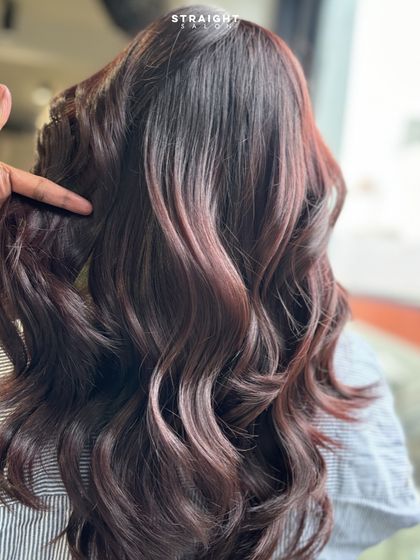 A stylist's hand points out the details in the color, showing the seamless blend.
