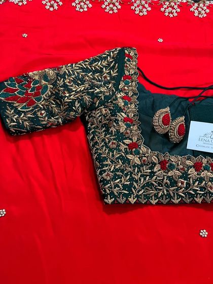 A classic combination of bottle green and red for a bridal look. This blouse is crafted with intricate gold zardozi work in a leafy pattern, with pops of red embroidery to match the saree.