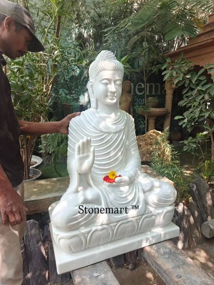 An artisan inspects the final details of a 3-foot white marble Buddha. We ensure every sculpture meets our high standards of quality before it is shipped.