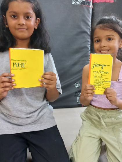 Fixed! Two young girls proudly display the books they bound themselves. It's a wonderful skill and a beautiful result.
