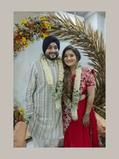 A lovely portrait of the newly married couple after their intimate home ceremony. They stand proudly, adorned with garlands, ready to start their new life.