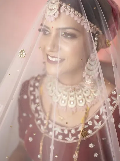 A bride's portrait is more than just a photo; it's a reflection of her journey. This shot, with the veil gently framing her smile, captures the anticipation and quiet joy of the wedding day in a timeless and emotional way.
