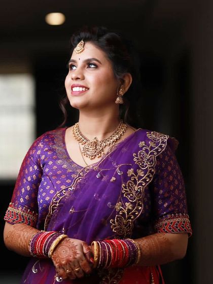 Sheela looking up, radiant and happy, during her engagement ceremony. Her makeup is designed to look beautiful from every angle.
