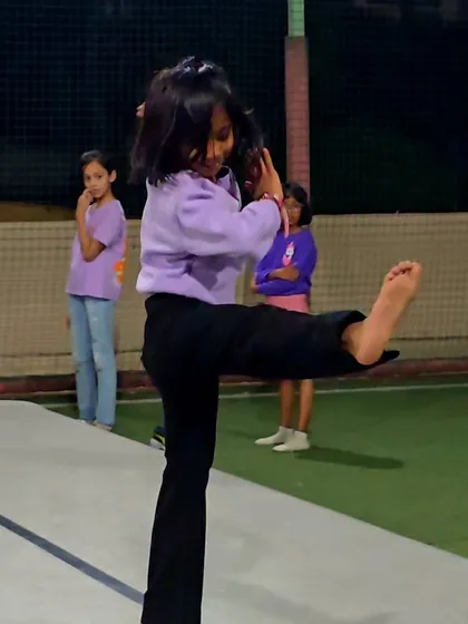 A young girl practices a martial arts kick during a birthday party. We incorporate a variety of disciplines into our events to keep things exciting and introduce kids to new forms of movement.