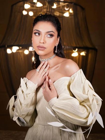 A close-up of the modern, leaf-detailed dress look. The makeup is soft and ethereal, with a focus on a dewy complexion.