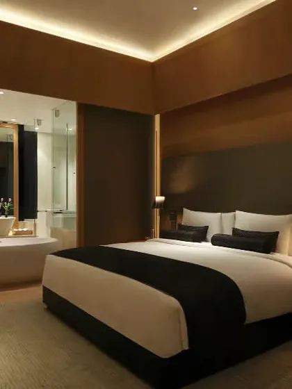 This view shows the layout of one of our luxury rooms, where the bedroom and bathroom spaces flow into each other, creating a sense of openness and modern comfort.