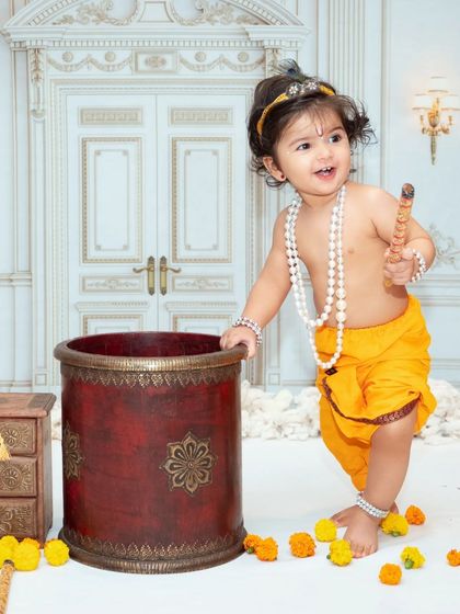 A happy little Krishna ready to play. Our studio is filled with props to create an authentic and fun atmosphere for these festive shoots.