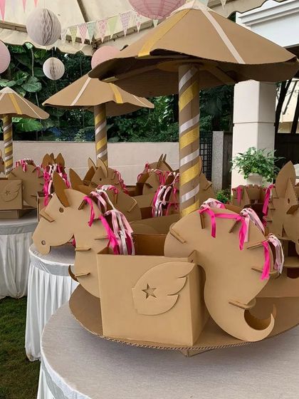 In addition to small favors, I also create larger centerpiece items. This cardboard carousel was used as a table centerpiece and a creative way to hold party favor boxes, tying the entire theme together beautifully.