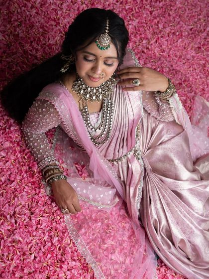From my Maharani Series, this light pink Kanjivaram saree is where tradition meets modern artistry. I've adorned it with intricate zardozi and paired it with a net handwork blouse and a regal dupatta, a tribute to the ancient queens of India.