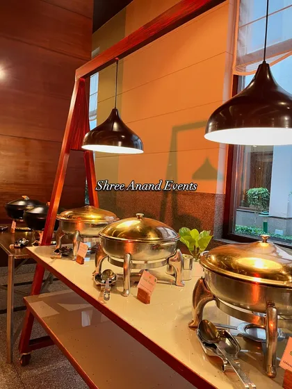 This image focuses on the warm, inviting look of the buffet station. The combination of the wooden frames, warm lighting, and gleaming serving dishes makes the food presentation very appealing.