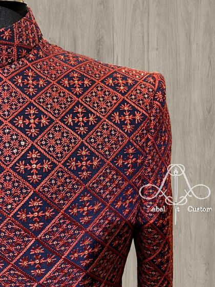 A close-up look at the fine craftsmanship of a custom bandhgala. This piece features detailed red and navy geometric embroidery, showcasing the precision and artistry that goes into my ethnic wear.