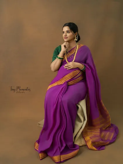 A thoughtful, seated portrait that showcases the beautiful drape of the Mysore silk saree and the mother's serene expression.