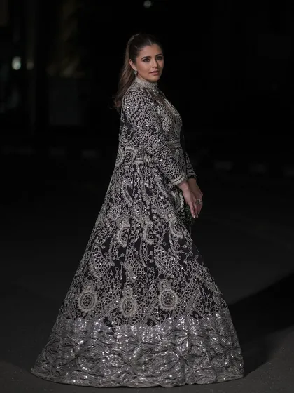 The full view of this sangeet look shows how the makeup and outfit work together to create a stunning effect. The luminous glam is the perfect complement to the detailed black and silver ensemble.