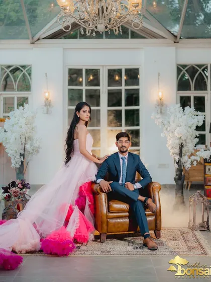 A wide shot that captures the grandeur of the room and the couple's stylish presence within it. The smoke effect adds a touch of mystique.