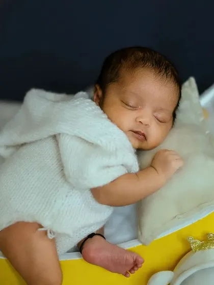The baby is nestled on a tiny pillow, ensuring they are fully supported and comfortable during the photoshoot. Every pose is done with the utmost care.