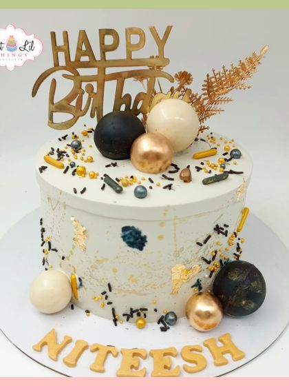 A modern and stylish birthday cake for Niteesh. This design features a sprinkle and splatter effect in black and gold, with coordinating spheres for a chic look.