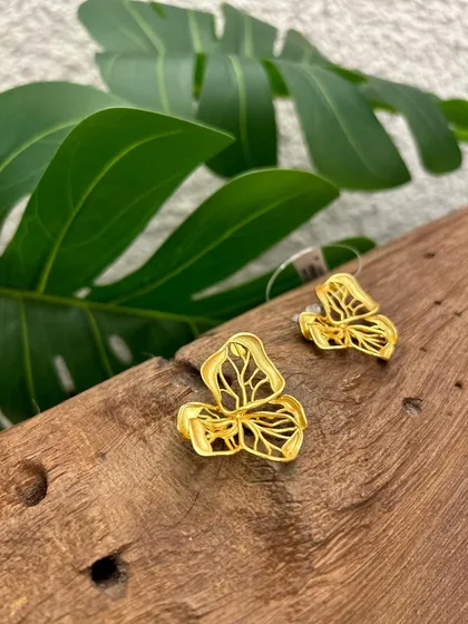 Inspired by nature, these gold earrings feature a delicate, cut-out leaf design, perfect for adding a touch of organic elegance to any outfit.