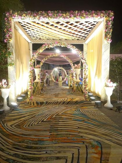 A closer look at the layered entrance design with a wooden trellis, floral arches, and a vibrant printed carpet. This setup shows how I combine different textures and elements for a rich visual experience.