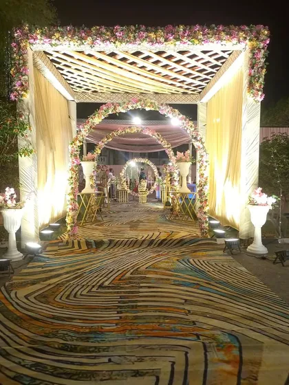 A closer look at the layered entrance design with a wooden trellis, floral arches, and a vibrant printed carpet. This setup shows how I combine different textures and elements for a rich visual experience.