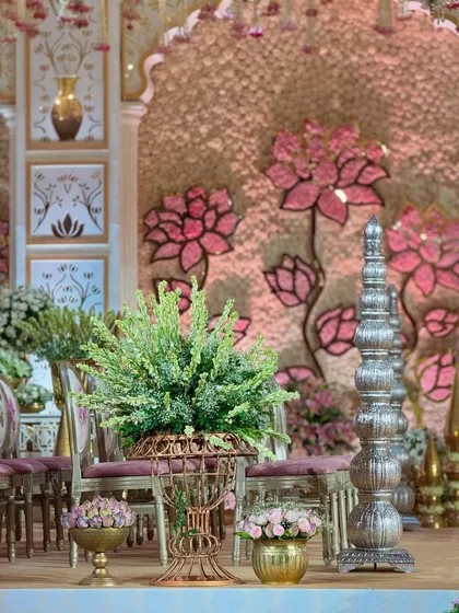 A detail shot from the stage, showing the traditional silver decor pieces and lush floral arrangements that create a sense of opulence and grandeur.