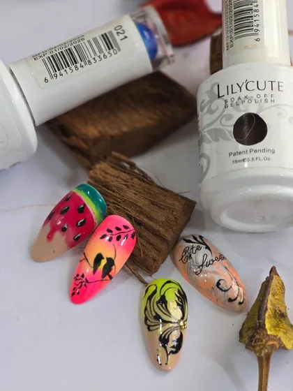 A display of summer-themed nail art, including a watermelon design and floral patterns on a nude base.