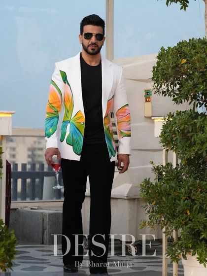 A full-length view of the white butterfly-print blazer. Paired with black trousers, it creates a striking contrast that is both artistic and sophisticated.