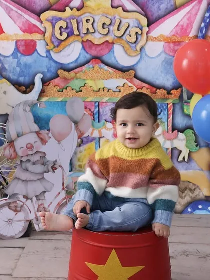The star of the show. This portrait from our carnival theme places the baby front and center, sitting on a circus prop. The colorful background and balloons add to the festive atmosphere.