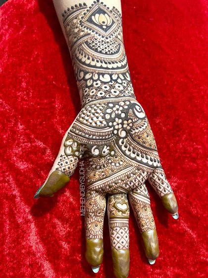 A single hand from a bold engagement design, featuring a prominent lotus motif on the forearm.