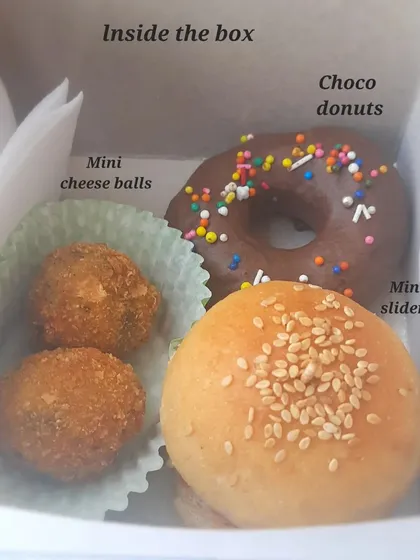 A peek inside one of my popular kids' party boxes. This one has mini sliders with homemade patties, mini cheese balls, and a choco donut, all perfectly portioned for little ones.
