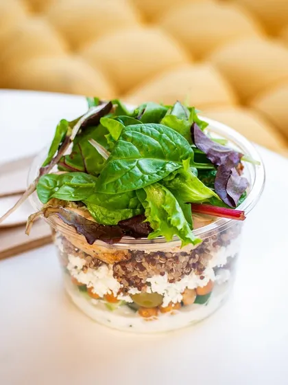 A healthy salad in a to-go container, showing that takeaway food can be both beautiful and nutritious.
