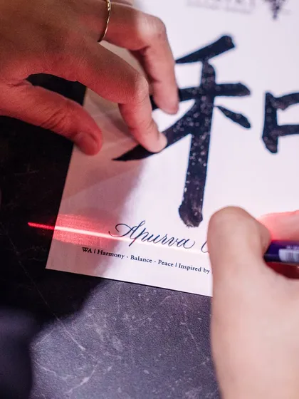 A close-up from the Suntory Hibiki event, showing my pen adding a guest's name to a frame. The red laser guide helps ensure perfect alignment every time.