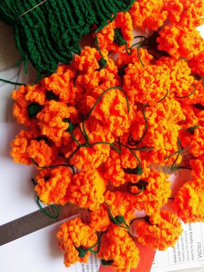 Getting ready for Navratri with a pile of orange marigold flowers. The color orange signifies energy and happiness.