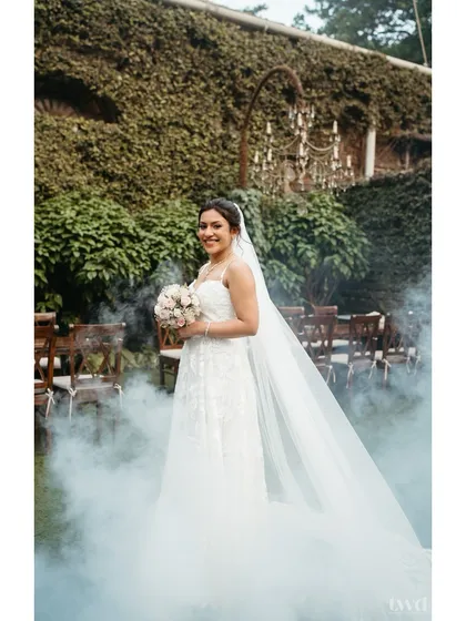 A bride emerging from a cloud of smoke, looking absolutely ethereal in her white wedding gown. This shot is pure magic, capturing a dreamy and cinematic bridal moment.