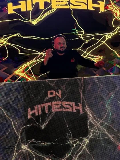 Pointing at the camera from my custom-branded DJ booth. The visuals extend from the main screen right down to the console itself for a cohesive look.