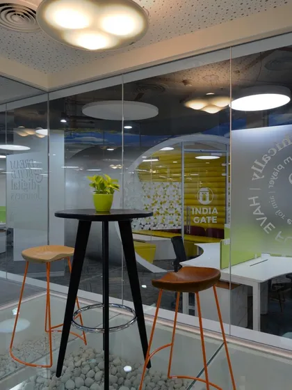 Why do interview rooms need to be formal? This informal meeting space features bar stools and a high table, with a glass wall that looks out onto the office.