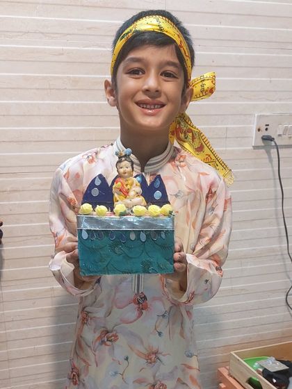 This smiling artist is showing off the beautiful Krishna setup he created. Our festive workshops are all about hands-on participation and cultural learning.