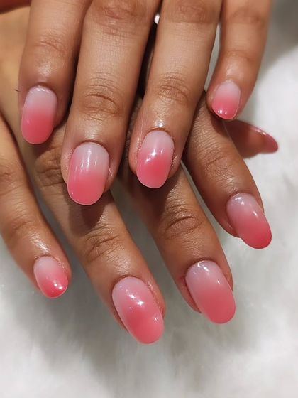 The perfect ombre effect. This design shows a seamless blend from a sheer nude base to a soft pink tip on short, oval nails. It's a timeless and sophisticated choice.