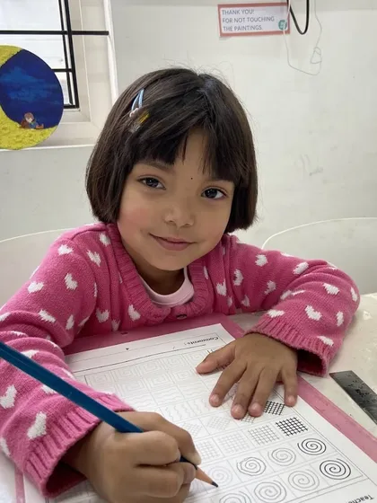 Here, a student practices line work and patterns using a pencil, an essential exercise for developing fine motor control and attention to detail. Our curriculum includes structured activities that build fundamental drawing skills.