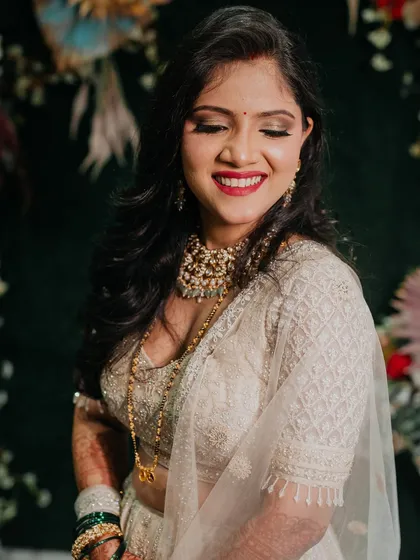A close-up of Sejal's reception makeup. The look features shimmering eyeshadow, a bold red lip, and flawless skin.