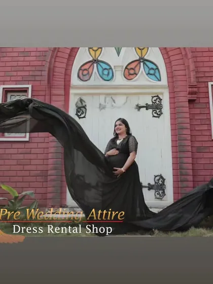 The black flying tail gown creates a stunning visual arc in this outdoor shot. It's a versatile piece that adds a sense of drama and sophistication to pregnancy photoshoots in various architectural settings.