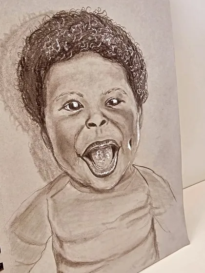 A third view of the happy child sketch, highlighting the texture of the paper and the softness of the pencil strokes.
