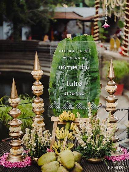 A unique welcome sign for a South Indian wedding, using a banana leaf and clear acrylic for a modern twist on tradition.