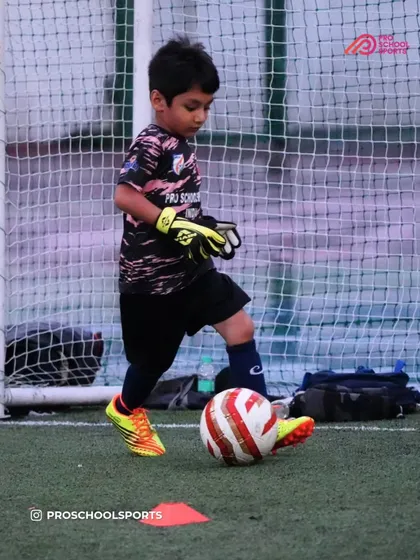 A young goalkeeper gets comfortable with the ball at his feet, an essential part of modern goalkeeping.
