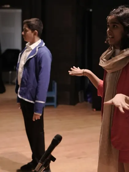 An actor using expressive hand gestures to tell her story during a performance. We teach children that body language is just as important as the words they speak.